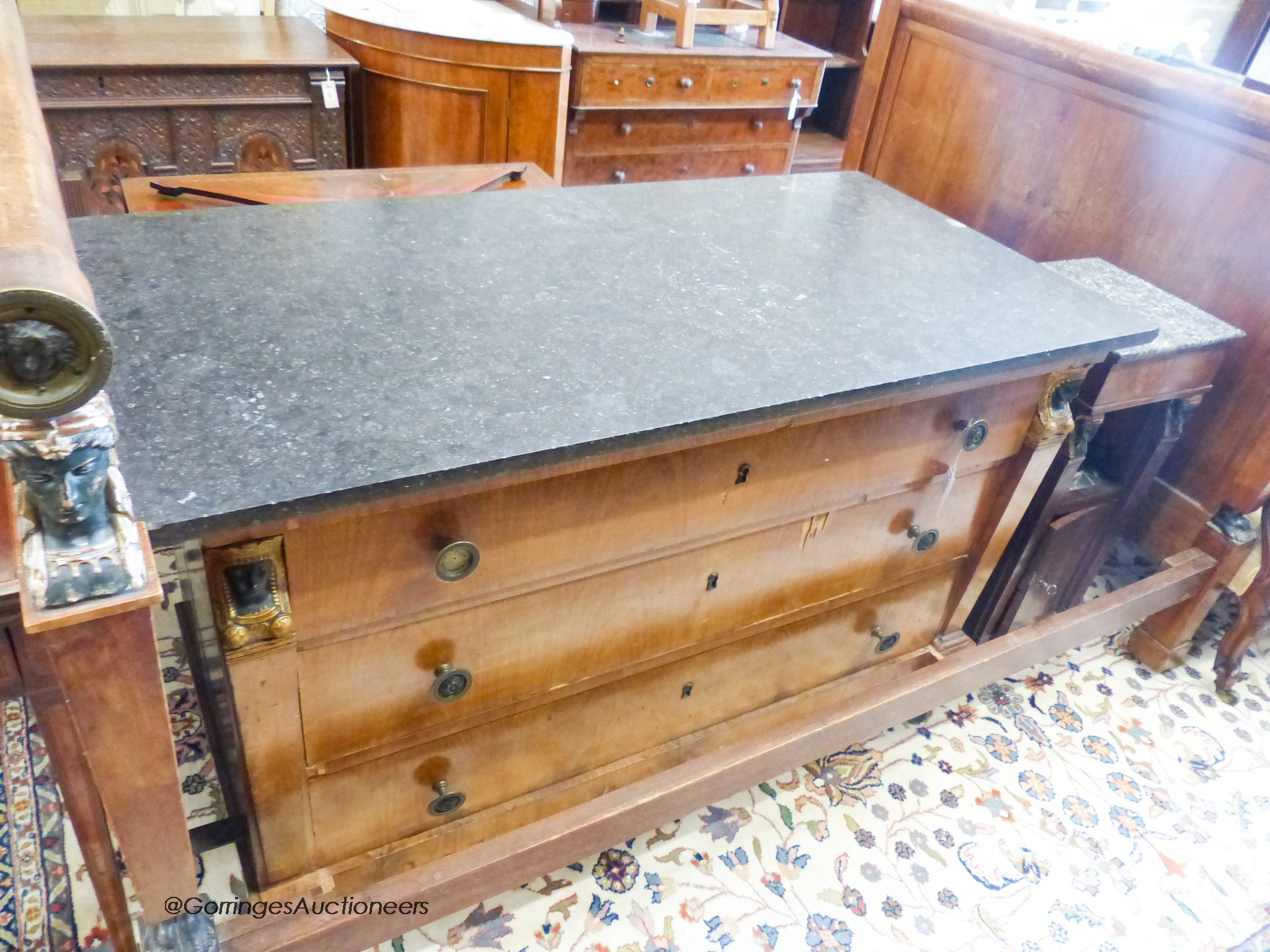 A 19th century French mahogany Egyptian taste three piece bedroom suite, comprising a three quarter size bed, a marble topped three dra
